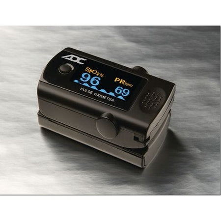 A digital pulse oximeter with a black casing, displaying readings on a blue LCD screen.