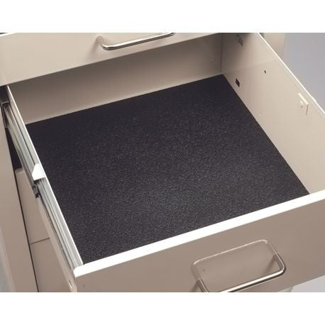 A black drawer liner placed inside an open drawer, with a textured surface.